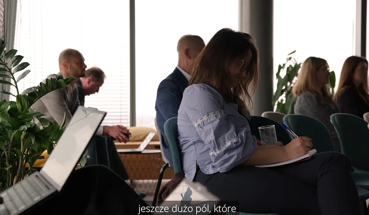 Fragment nagrania wideo przedstawiający skupionych uczestników wydarzenia biznesowego słuchających prelekcji podczas konferencji B2B